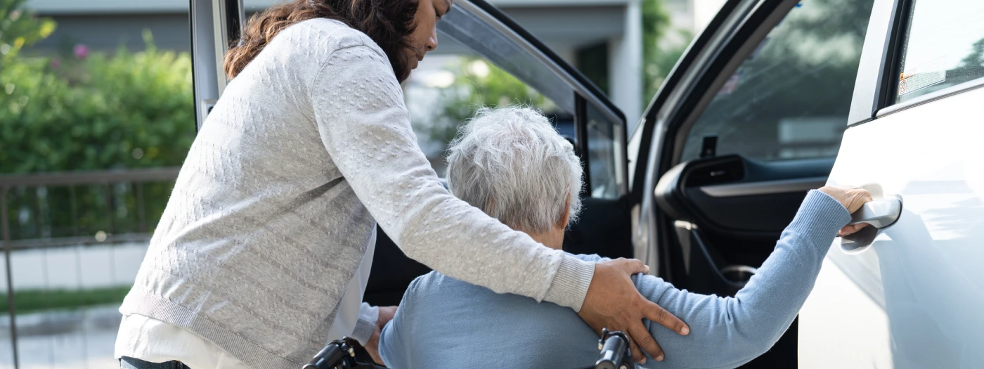 Support worker providing transport support with NDIS participant